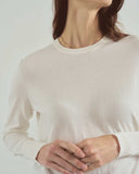 Person wearing a beige sweater against a white background