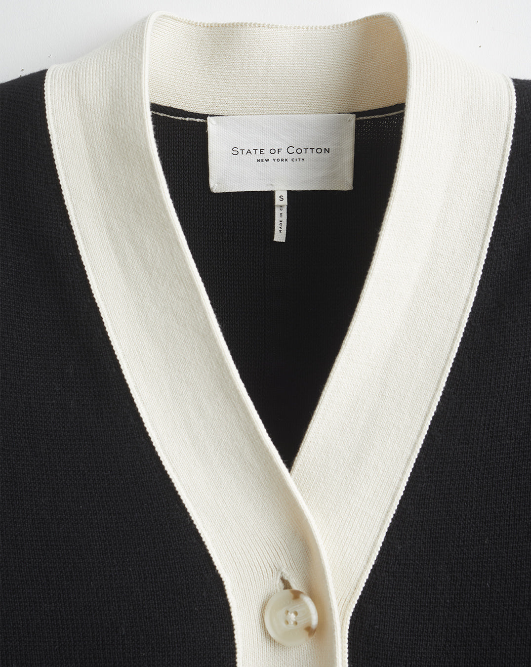 Detail shot of The Perry Tipped Cotton Cardigan in black and ivory — Egyptian cotton